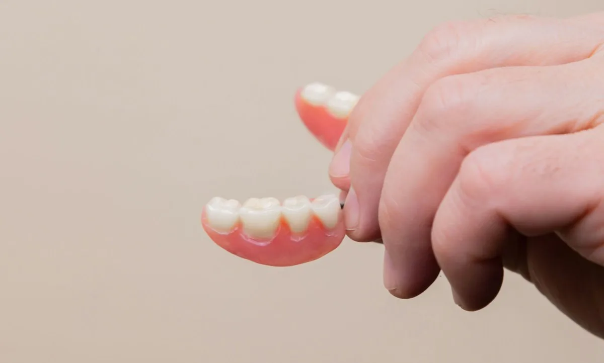 Hand holding a partial denture